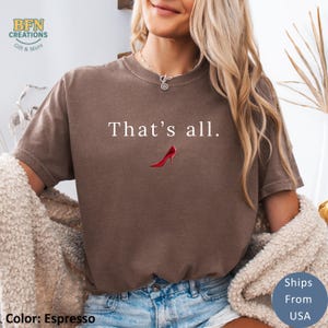 May include: Espresso-colored t-shirt with the text "That's all." and a red high-heeled shoe graphic. The shirt is a comfortable, casual style, perfect for everyday wear. The shirt is a solid color.