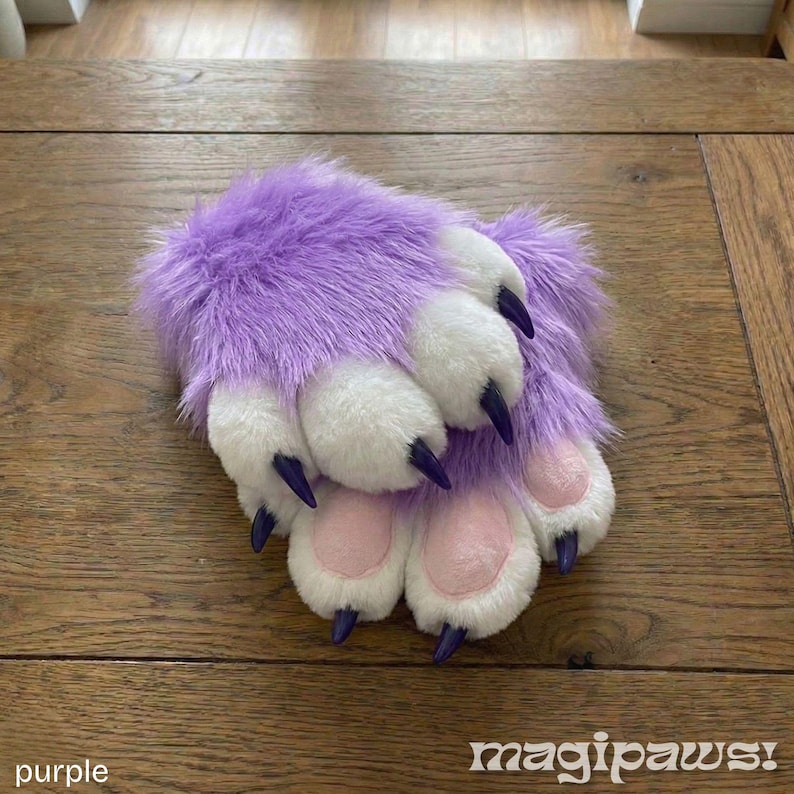 Puede incluir: Un par de guantes de pata peludos morados y blancos con garras negras y almohadillas rosas. El texto "magipaws!" est&aacute; en la esquina inferior derecha y la palabra "purple" en la esquina inferior izquierda.