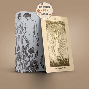 Può includere: Un mazzo di carte dei tarocchi. La carta beige chiaro mostra un'illustrazione di una persona appesa a testa in giù, con l'etichetta "THE HANGED MAN". La scatola azzurra ha disegni a tratto nero di figure e rose. Un adesivo recita "NO EXTRA - US - TAXES."