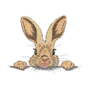 以下が含まれることがあります： 長い耳とピンクの鼻を持つ茶色のウサギの刺繍デザイン。灰色の表面から覗いています。ウサギの目は黒く、ひげが見えます。デザインは白い背景にあります。