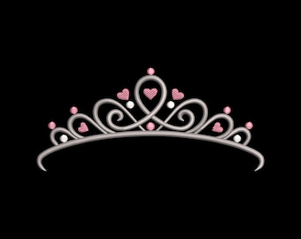 May include: A silver tiara with pink heart and pearl accents. The tiara features a curved base with swirling designs and small pink hearts. The design is set against a black background.