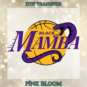 May include: A DTF transfer design featuring a purple snake over a yellow basketball with the words "BLACK MAMBA" in purple. The design includes the text "DTF TRANSFER" at the top and "PINK BLOOM" at the bottom, all set against a blurred background.