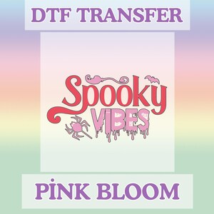 May include: A DTF transfer design with the words "Spooky Vibes" in a pink, dripping font, with a spider and bat graphic. The design is set against a gradient background and includes the text "Pink Bloom".