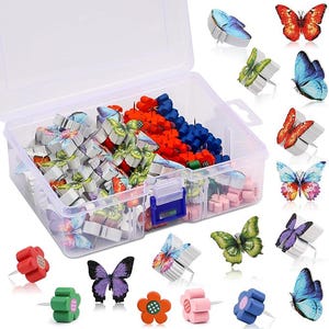 May include: A clear plastic storage box filled with decorative push pins. The push pins are butterfly and flower shaped, in various colors including red, blue, green, pink, and purple. Some butterfly push pins are outside the box.