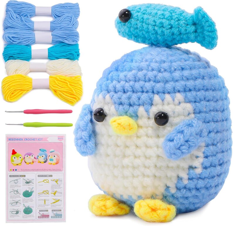 K&ouml;nnte beinhalten: Ein H&auml;kelset mit einem blau-wei&szlig;en Pinguin mit Fischhut, Garn in verschiedenen Blau-, Wei&szlig;- und Gelbt&ouml;nen, H&auml;kelnadeln und einer Anf&auml;ngeranleitung. Das Set enth&auml;lt Materialien zum Basteln.