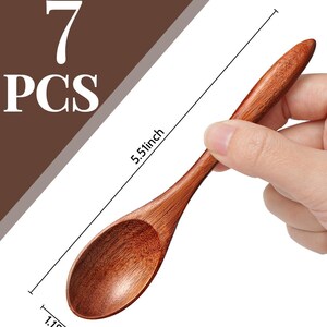 May include: A set of seven wooden spoons. Each spoon is a warm brown color, with a rounded bowl and a long handle. The spoon measures 5.51 inches long and 1.18 inches wide. The text "7 PCS" is in the upper left corner.