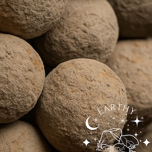 May include: A white ceramic mug with a black handle and the text "But First, Coffee" in a bold, black font. The mug is set against a blurred background, suggesting a cosy setting.