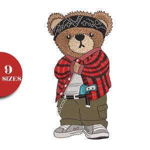 May include: Embroidered design of a brown teddy bear wearing a black bandana, red and black plaid shirt, gray shirt, and olive green pants. The bear has a small toy gun and is wearing gray sneakers. A red circle with the text "9 SIZES" is on the left.