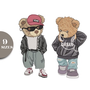 May include: Two embroidered teddy bears in urban streetwear. One bear wears a red cap with "YEAH" and sunglasses. The other bear wears a hoodie with "URBAN" and ripped jeans. The image also includes a graphic that says "9 SIZES".