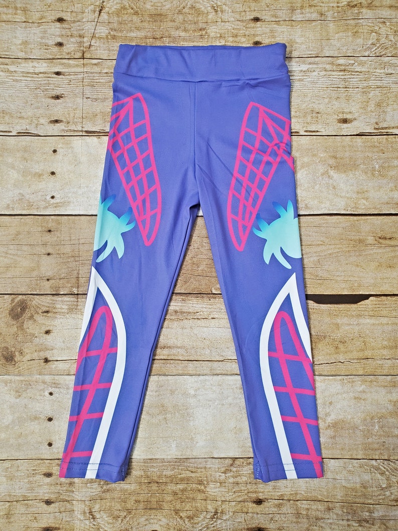 May include: Purple leggings with a white and pink design featuring a geometric pattern. The design is on the sides of the leggings.