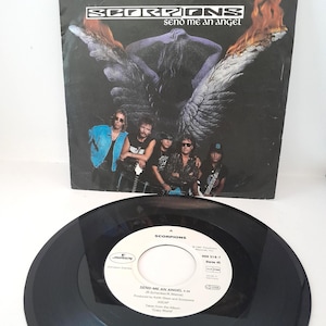 Peut inclure: Un disque vinyle et une pochette d'album pour la chanson "Send Me An Angel" du groupe Scorpions. La pochette de l'album présente les membres du groupe et un graphisme d'ange avec des flammes. Le disque est noir avec du texte blanc.