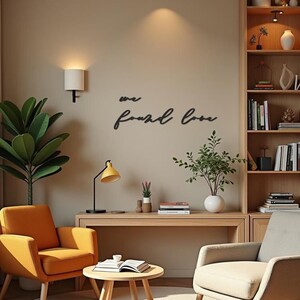 Può includere: Interno di un soggiorno con una poltrona arancione, una scrivania in legno e un tavolino rotondo. Una lampada da scrivania gialla e un'applique illuminano la stanza. Le parole "we found love" sono esposte sulla parete. Una libreria è visibile sullo sfondo.