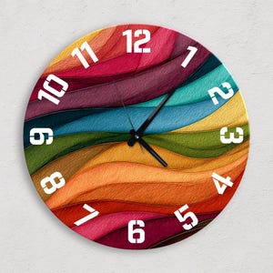 Może przedstawiać: Okrągły zegar ścienny z kolorowym, abstrakcyjnym wzorem. Tarcza zegara ma falisty wzór w odcieniach czerwieni, pomarańczy, żółci, zieleni, niebieskiego i fioletu. Białe cyfry oznaczają godziny, a czarne wskazówki wskazują czas.
