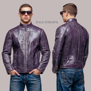 May include: A purple leather jacket with a snakeskin pattern. The jacket has a zipper closure, a stand-up collar, and zippered pockets. The jacket is shown from the front and back. The model is wearing blue jeans and sunglasses. The text "DALEATHERPK" is visible.