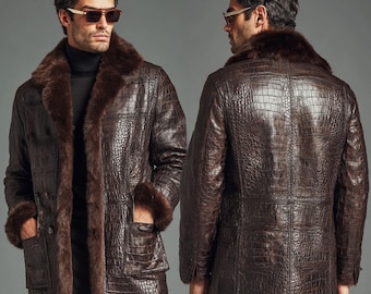 May include: A brown leather coat with a crocodile texture, featuring a fur collar and cuffs. The coat has a classic design with a button closure and pockets. The image shows the front and back of the coat.
