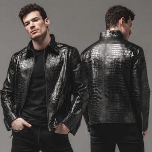 Puede incluir: Chaqueta de cuero negro con textura de piel de cocodrilo. La chaqueta tiene cierre de cremallera y cuello. El modelo lleva una camiseta negra y pantalones negros.