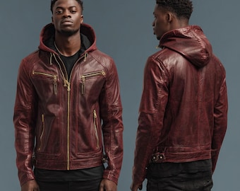 Puede incluir: Chaqueta de cuero burdeos con capucha y cremalleras doradas. La chaqueta tiene múltiples bolsillos y un diseño entallado. El modelo lleva una camiseta negra y pantalones negros. Una opción de abrigo elegante.