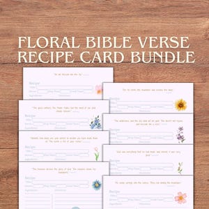 May include: A bundle of eight floral Bible verse recipe cards. Each card features a floral design and space for recipe details. The cards are white with pink accents and are arranged on a wooden surface. The text "FLORAL BIBLE VERSE RECIPE CARD BUNDLE" is at the top.