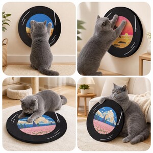 Pode incluir: Um gato cinzento interage com um arranhador circular preto para gatos projetado para se parecer com um disco de vinil. O arranhador apresenta um design de paisagem colorido. O gato &eacute; visto arranhando e descansando no arranhador.