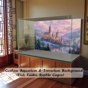 May include: A large glass aquarium tank featuring a decorative background print of a castle on a hill overlooking a lake at sunset. The tank sits on a wooden cabinet. The text Custom Aquarium & Terrarium Background (Fish Tanks, Reptile Cages) is visible.