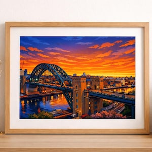 May include: A framed print of a bridge over a river at sunset. The bridge, with its distinctive arch, is rendered in blue and green hues. The sky is a striking blend of orange, yellow, and blue. The artwork is presented on a wooden surface.