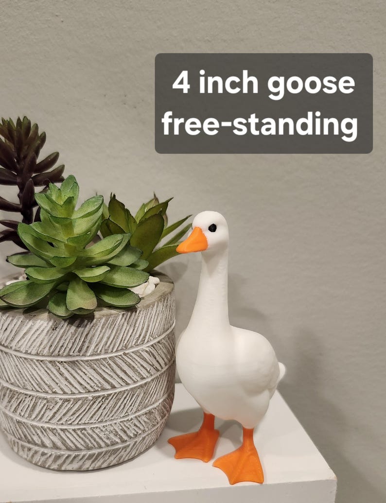 May include: A white goose figurine with an orange beak and orange webbed feet. The goose is free-standing and measures 4 inches in height. The text 4 inch goose free-standing is displayed in a dark gray box above the goose.