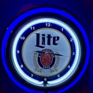 May include: A round clock with a blue neon light border. The clock face is white with black numerals and hands. The word "Lite" is prominently displayed, along with "AFE Pilsner Beer".