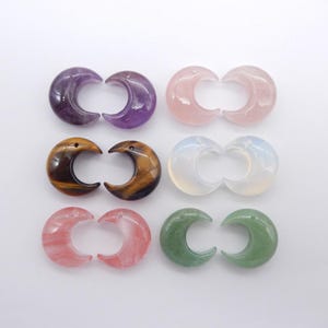 Puede incluir: Un surtido de colgantes de piedras preciosas en forma de media luna en varios colores. La colección incluye amatista, cuarzo rosa, ojo de tigre, ópalo, cuarzo rosa y aventurina verde. Cada colgante está pulido y tiene un agujero.
