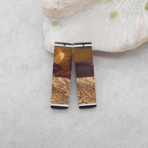 Puede incluir: Dos pendientes rectangulares con apariencia de piedra natural. Los pendientes presentan una mezcla de colores marrón, beige y negro. La parte superior de cada pendiente tiene una franja negra con una franja blanca debajo. La parte inferior tiene un aspecto beige texturizado.