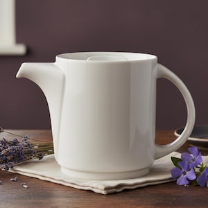 May include: A set of three ceramic mugs with a speckled, matte finish. Each mug features a different color: light blue, cream, and gray. The mugs have a simple, modern design and a comfortable handle.
