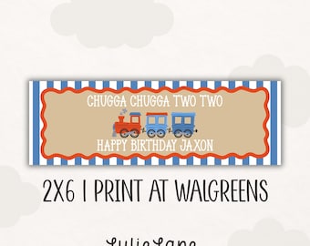 May include: A rectangular banner with a blue and white striped border and a scalloped orange edge. The center features a tan background with a red and blue train illustration, the text CHUGGA CHUGGA TWO TWO, and HAPPY BIRTHDAY JAXON.