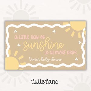 May include: A rectangular baby shower invitation with a tan background, a white border, and yellow sun illustrations. The text reads "a little ray of sunshine is almost here" and "Novies baby shower". The Lulie Lane logo is at the bottom.