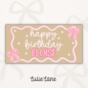 May include: A rectangular tan sign featuring a wavy pink border and two pink bows at the corners. The text reads happy birthday in white script and ELOISE in bold pink capital letters. Small white dots are scattered across the tan background.