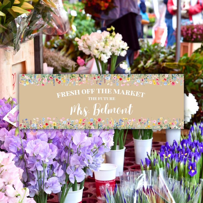 May include: A floral market scene with a banner reading "FRESH OFF THE MARKET THE FUTURE Mrs. Belmont." The banner is beige with a floral border. The scene includes bouquets of purple, white, and blue flowers in white vases.