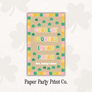 May include: A rectangular sign with the text "COOLEST CLOVERS IN THE PATCH" in pink, yellow, and green. The sign has a tan background with green clovers and a border of pink, yellow, and green squares. The text "Mrs. Ashby's Class" is also included.