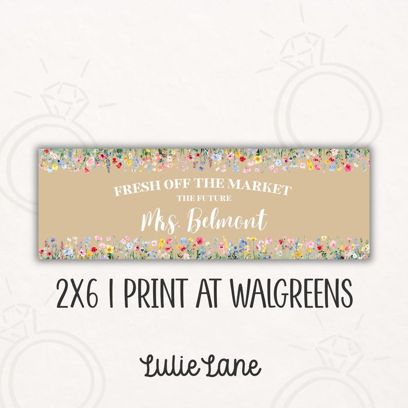 May include: A rectangular beige sign with floral borders and the text "FRESH OFF THE MARKET THE FUTURE Mrs. Belmont". Below the text is "2X6 I PRINT AT WALGREENS" and the brand name "Lulie Lane".
