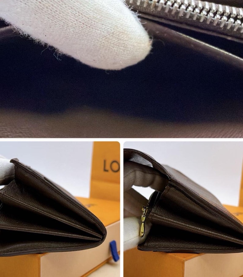 May include: Close-up of a brown leather wallet, partially open, revealing interior compartments. The wallet has a zipper closure and a gold-colored zipper pull. The leather appears to have a textured finish.