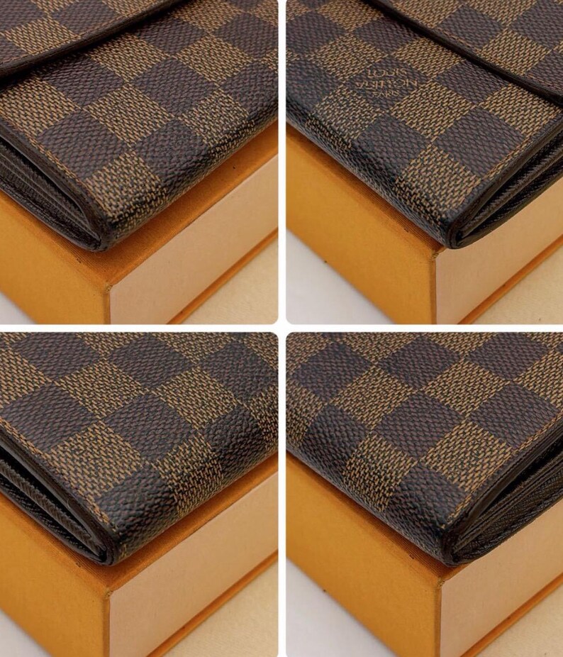 May include: Close-up of a brown and tan checkered wallet. The wallet is on top of a light brown box. The wallet has a dark brown border and a small logo in the upper right corner.