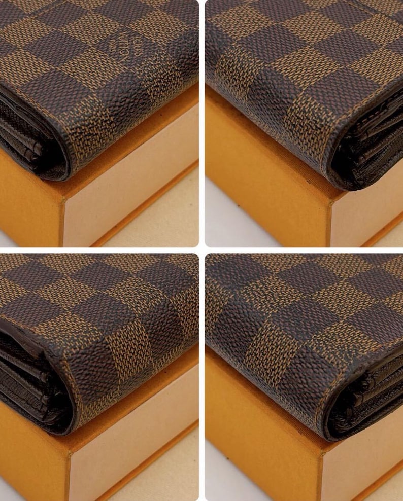 May include: Close-up of a brown and tan checkered wallet. The wallet is resting on a tan box. The wallet has a repeating pattern of squares.