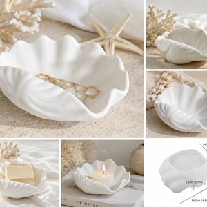 May include: A white ceramic dish shaped like a clam shell with a matte finish. The dish features a scalloped edge and a curved interior. A diagram shows the dimensions as 5.71 inches by 6.5 inches with a height of 2.17 inches.