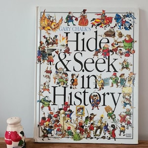 May include: A colourful children's book titled "Gary Chalk's Hide & Seek in History" with a busy illustration of people and animals from different historical periods.