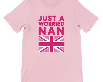 May include: A pale pink t-shirt featuring the text "JUST A WORRIED NAN" in pink, above a pink Union Jack flag. The t-shirt has a classic crew neck design.