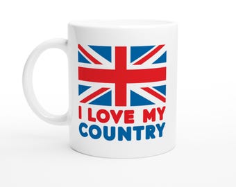 Puede incluir: Taza de cerámica blanca con el diseño de la bandera de la Union Jack en rojo, blanco y azul. La taza tiene el texto "I LOVE MY COUNTRY" en rojo y azul. La taza tiene un asa curva.