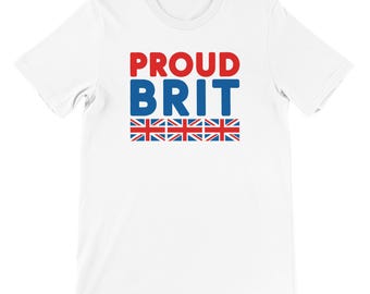 May include: White t-shirt featuring the text "PROUD BRIT" in red and blue. Below the text are six Union Jack flags. The shirt has a crew neck and short sleeves.