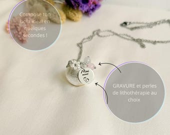 Könnte beinhalten: Eine silberfarbene Halskette mit einem runden Anhänger, einer kleinen Blumenverzierung und einer runden Platte, die mit dem Text "Mini nous" und einem Fußabdruck-Symbol graviert ist. Die Kette enthält zwei kleine Perlen und französische Texte.