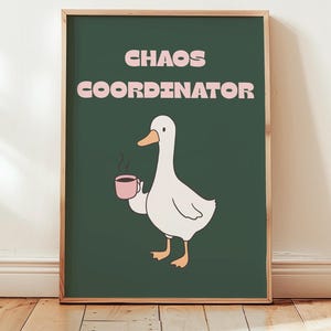 Può includere: Stampa incorniciata con un'anatra dei cartoni animati che tiene in mano una tazza rosa fumante. La scritta "CHAOS COORDINATOR" in rosa è sopra l'anatra su sfondo verde scuro. La cornice è marrone chiaro. Decorazione umoristica.