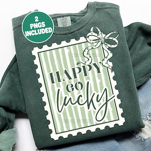 Puede incluir: Sudadera verde oscuro con un dise&ntilde;o blanco y verde que dice "Happy Go Lucky" dentro de un borde similar a un sello. Un lazo verde con tr&eacute;boles est&aacute; en la parte superior derecha. Las palabras "2 PNGS INCLUDED" est&aacute;n en un c&iacute;rculo verde en la parte superior izquierda.