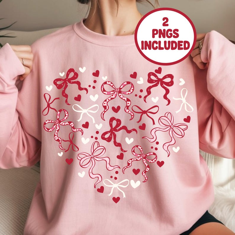 May include: A light pink sweatshirt featuring a heart-shaped design of red and white bows and hearts. The text "2 PNGS INCLUDED" is in a red circle. The long-sleeved top is a Valentine's Day or romantic-themed apparel item.