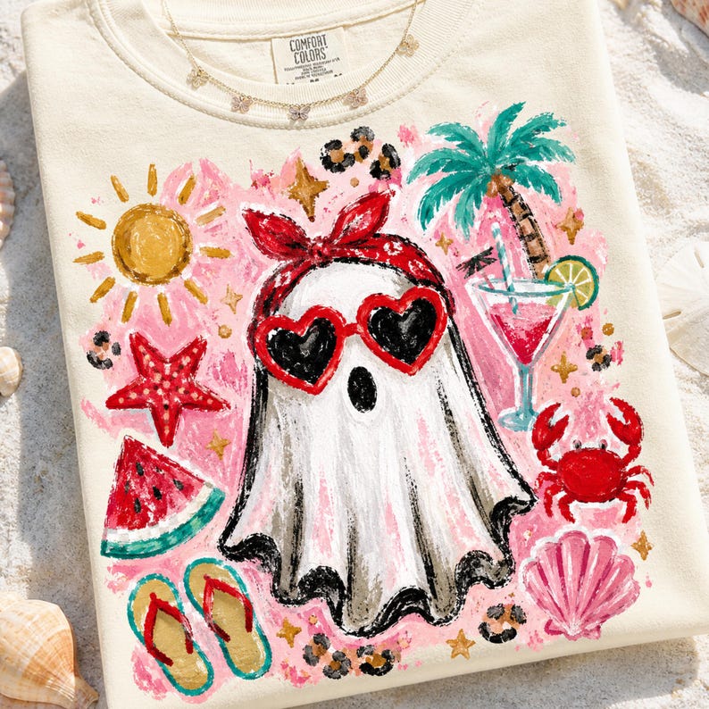 May include: Cream-colored sweatshirt with a whimsical beach-themed design. A white ghost wearing heart-shaped sunglasses and a red bandana is surrounded by a cocktail, palm tree, crab, and watermelon. The text "Comfort Colors" is visible.
