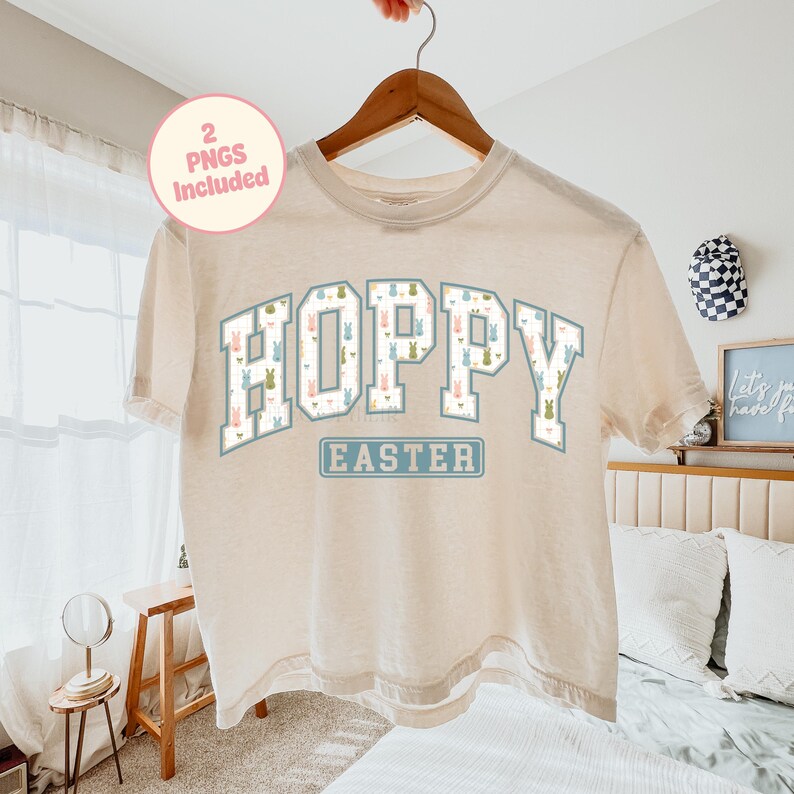 May include: A beige t-shirt with the word "HOPPY" in large, white, block letters filled with bunny patterns. The word "EASTER" is below in a blue rectangle. A pink circle with the text "2 PNGS Included" is in the upper left.